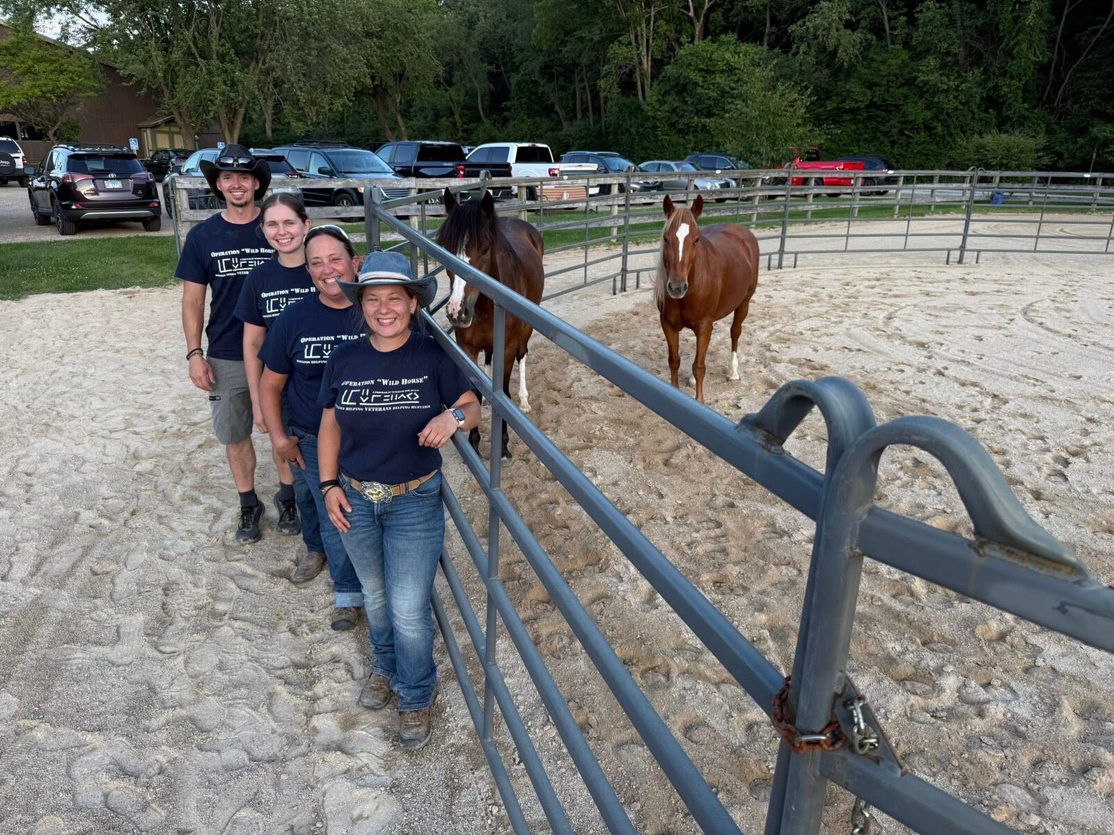 The Operation Wild Horse team at the round pen with two wild horses